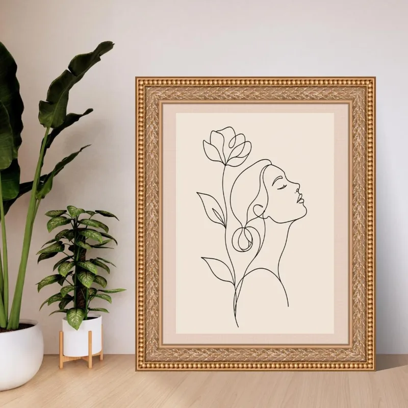 Minimalist black line art of a woman in profile with closed eyes and a stylized flower behind her head on a warm beige background